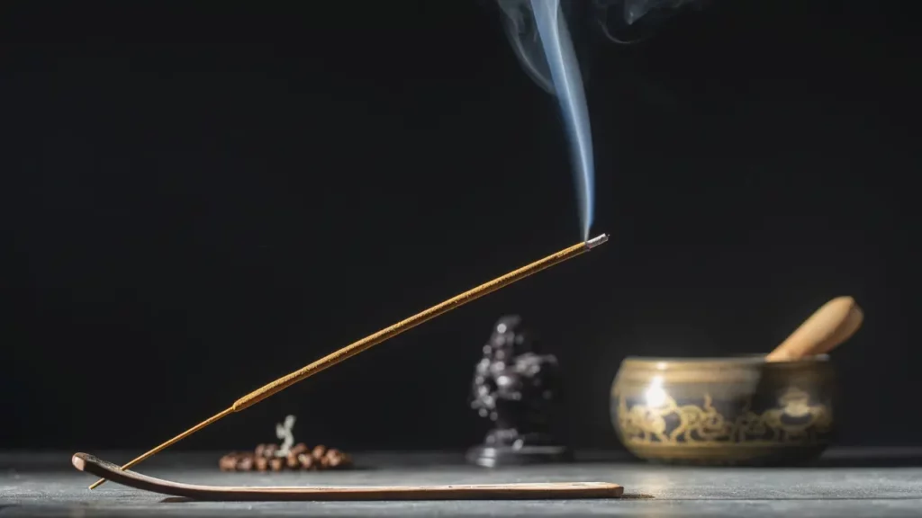 3. Rauhnacht Titelbild Räucherstäbchen das Brennt und im Hintergrund ein Budda, eine Gebetskette und eine Klangschale